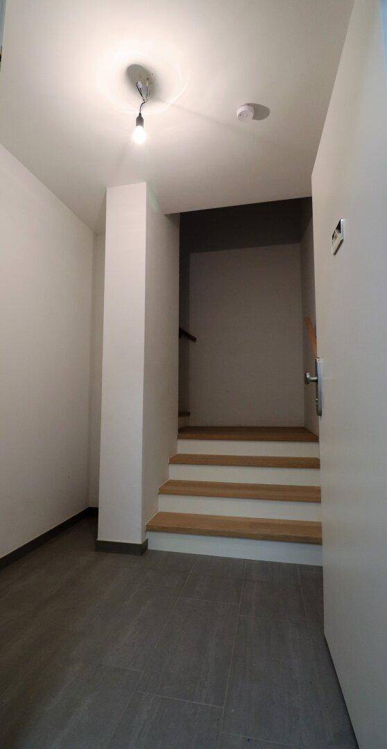 Heller Flur mit Treppenaufgang und schlichtem Design.