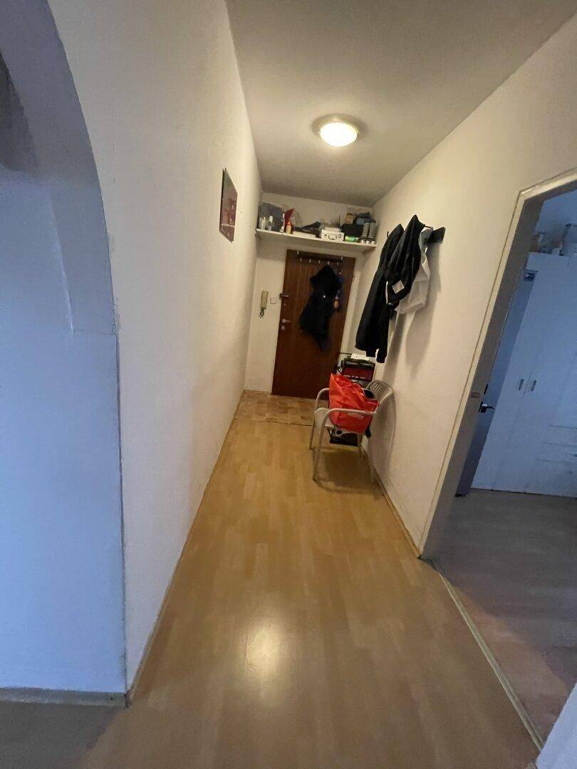 Eingangsbereich mit Garderobe, hellem Laminatboden und Zugang zu verschiedenen Zimmern.