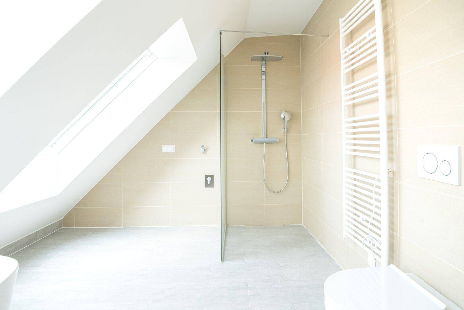 Modernes Badezimmer mit ebenerdiger Dusche, Wand-WC und beheiztem Handtuchhalter.