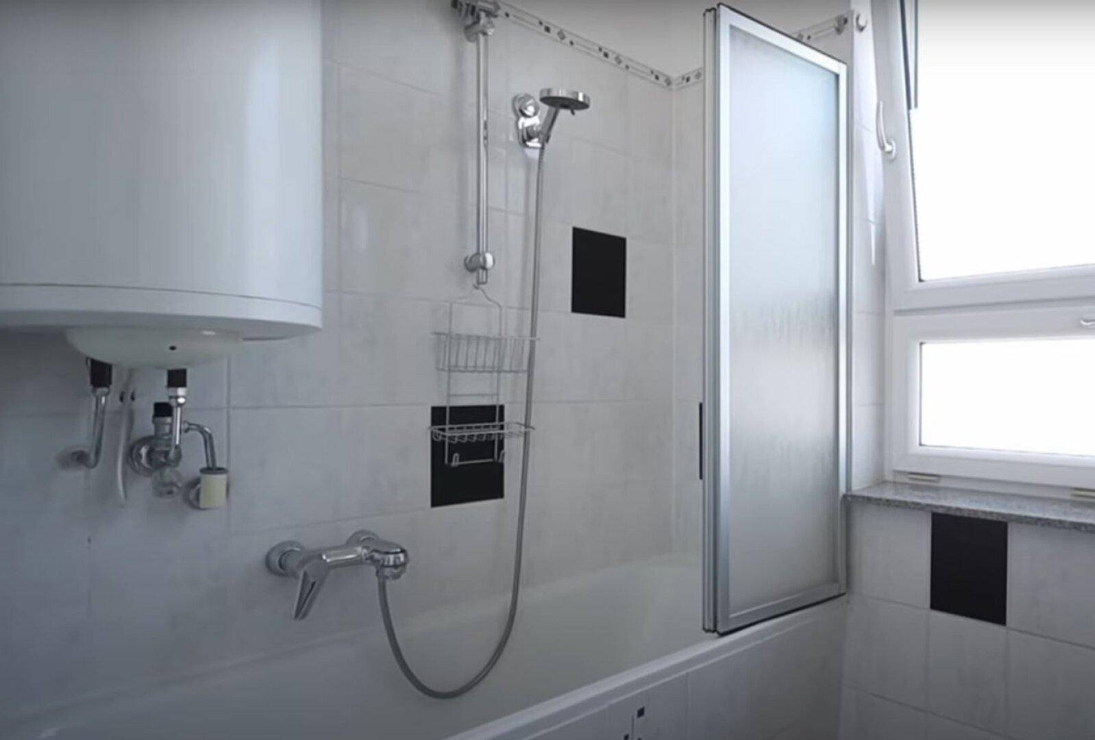 Badezimmer mit Badewanne, Duschvorrichtung, Boiler und einem Fenster für natürliche Belüftung.