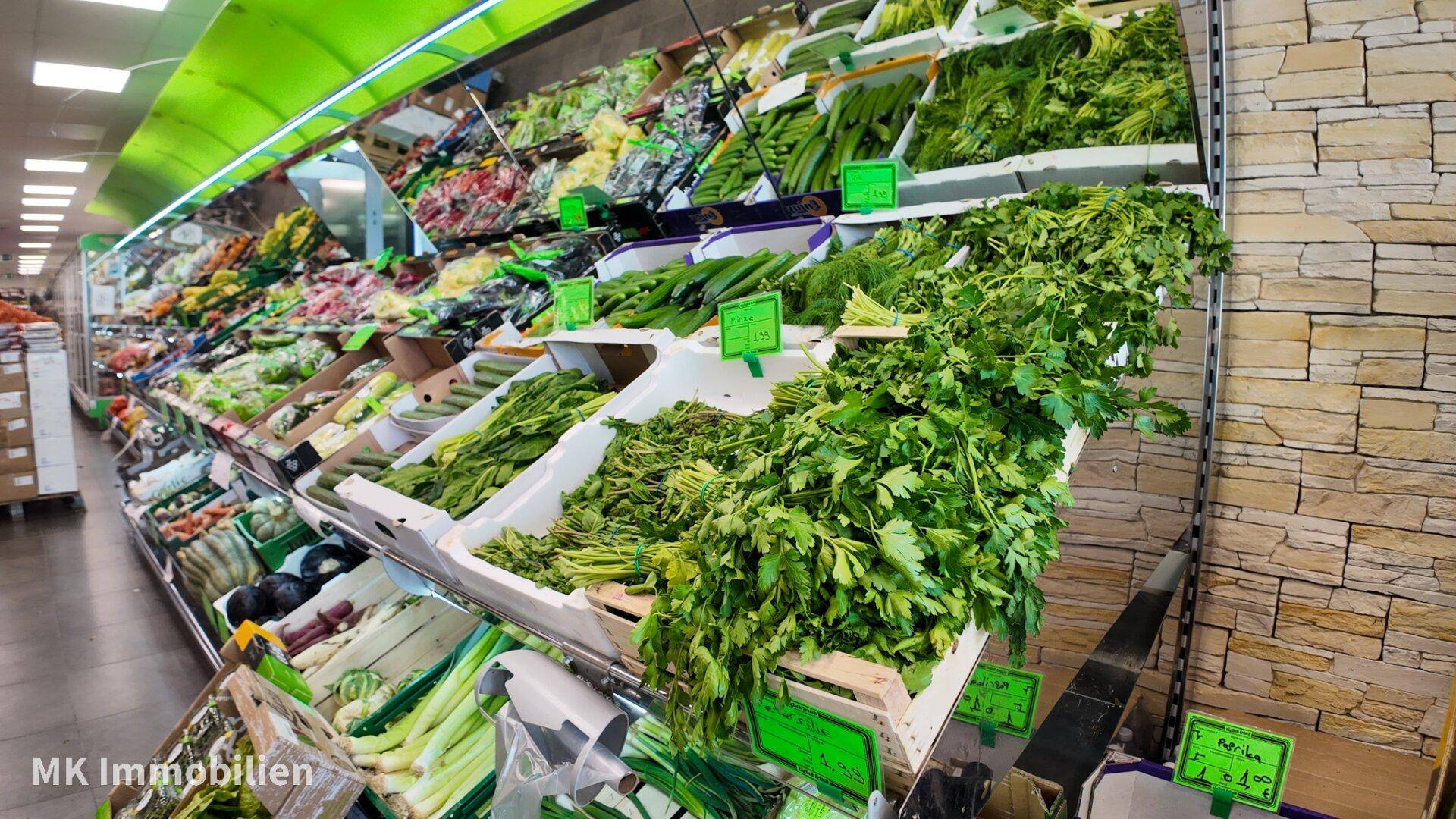 Frische und vielfältige Auswahl an Obst und Gemüse in der gut beleuchteten Auslage eines Supermarktes.