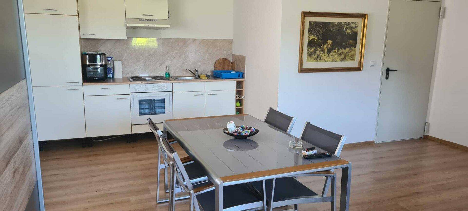 Einfache Küchenzeile mit Essbereich und Fenster, ideal für kleine Haushalte.