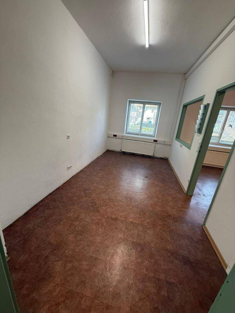 Leerer Raum mit Linoleumboden und Fenstern, der eine flexible Gestaltung ermöglicht.