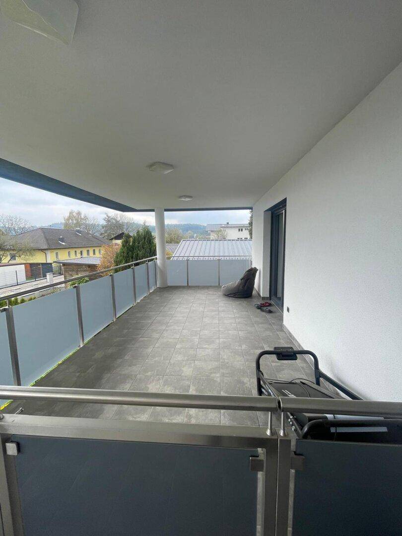 Großer Balkon mit moderner Glasbrüstung und viel Platz für Entspannung im Freien.