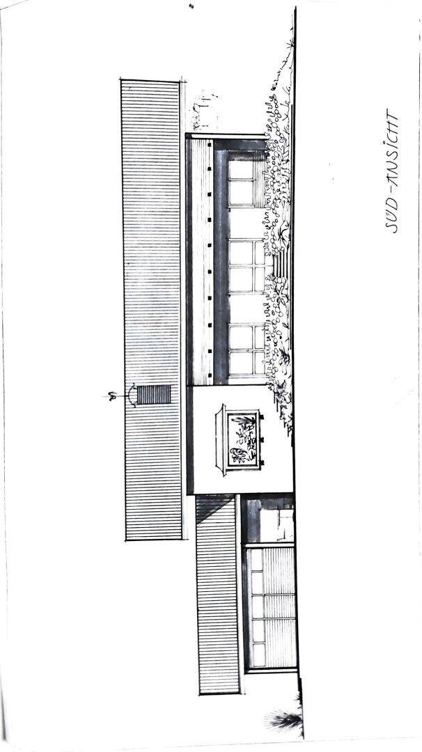 Südansicht des Gebäudes mit großen Fenstern und Balkon.