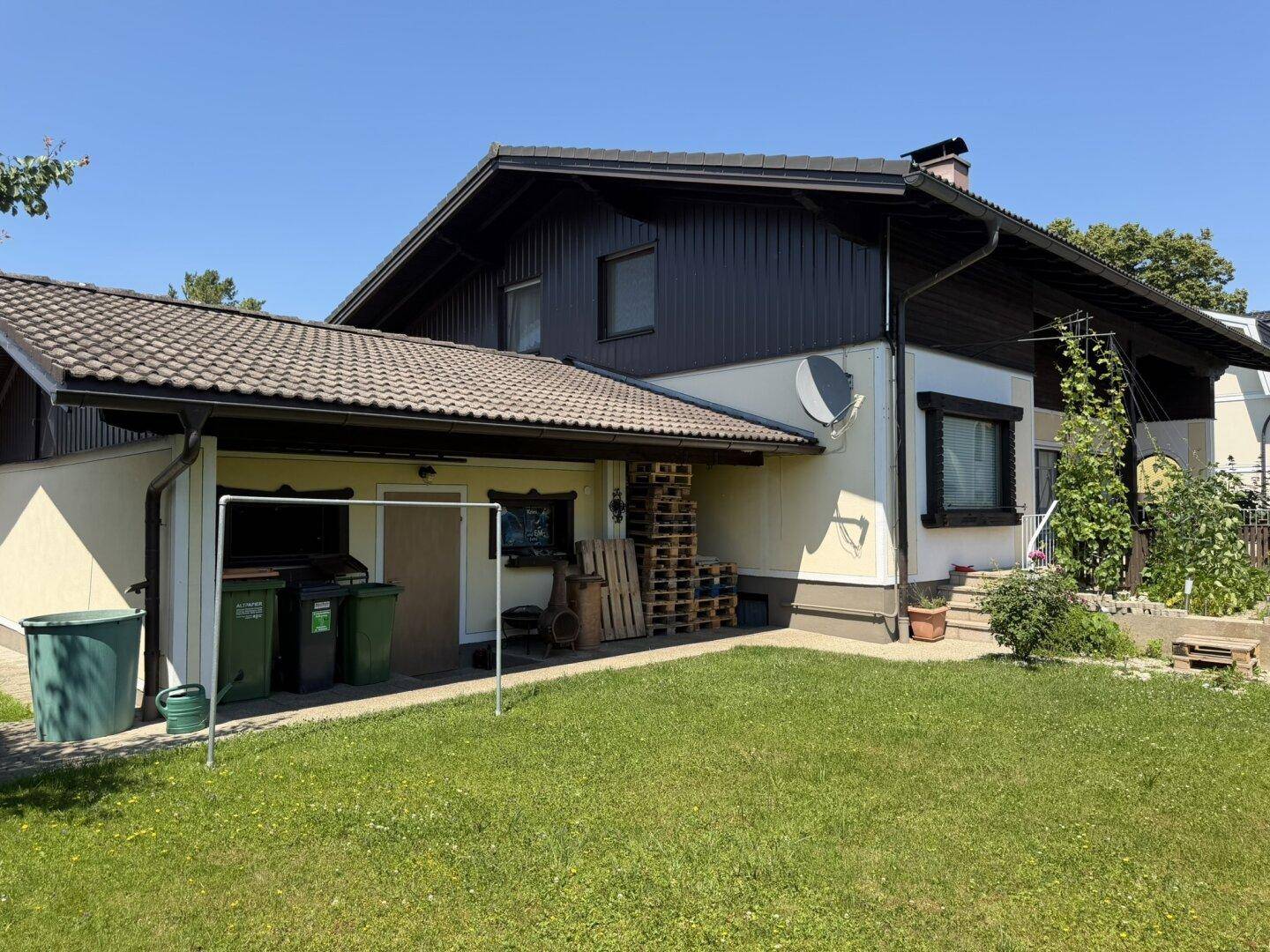 Ansicht des Hauses von der Gartenseite mit Anbau und gepflegter Rasenfläche.