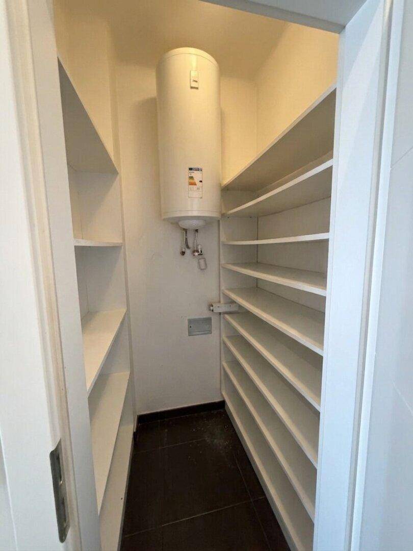 Praktischer Abstellraum mit vielen Regalen und einem Warmwasserboiler.
