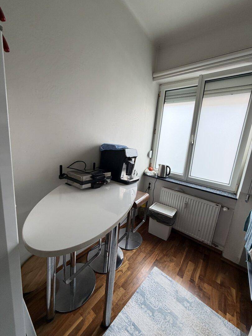 Kleiner Essbereich in der Küche mit Bartisch und Stühlen am Fenster.