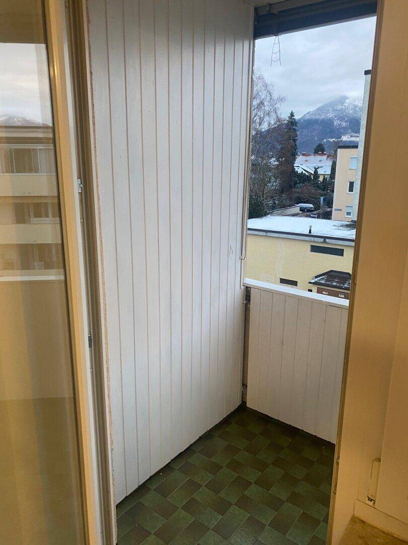 Balkon mit grünen Fliesen und weißer Verkleidung, bietet einen Blick auf die verschneite Umgebung.
