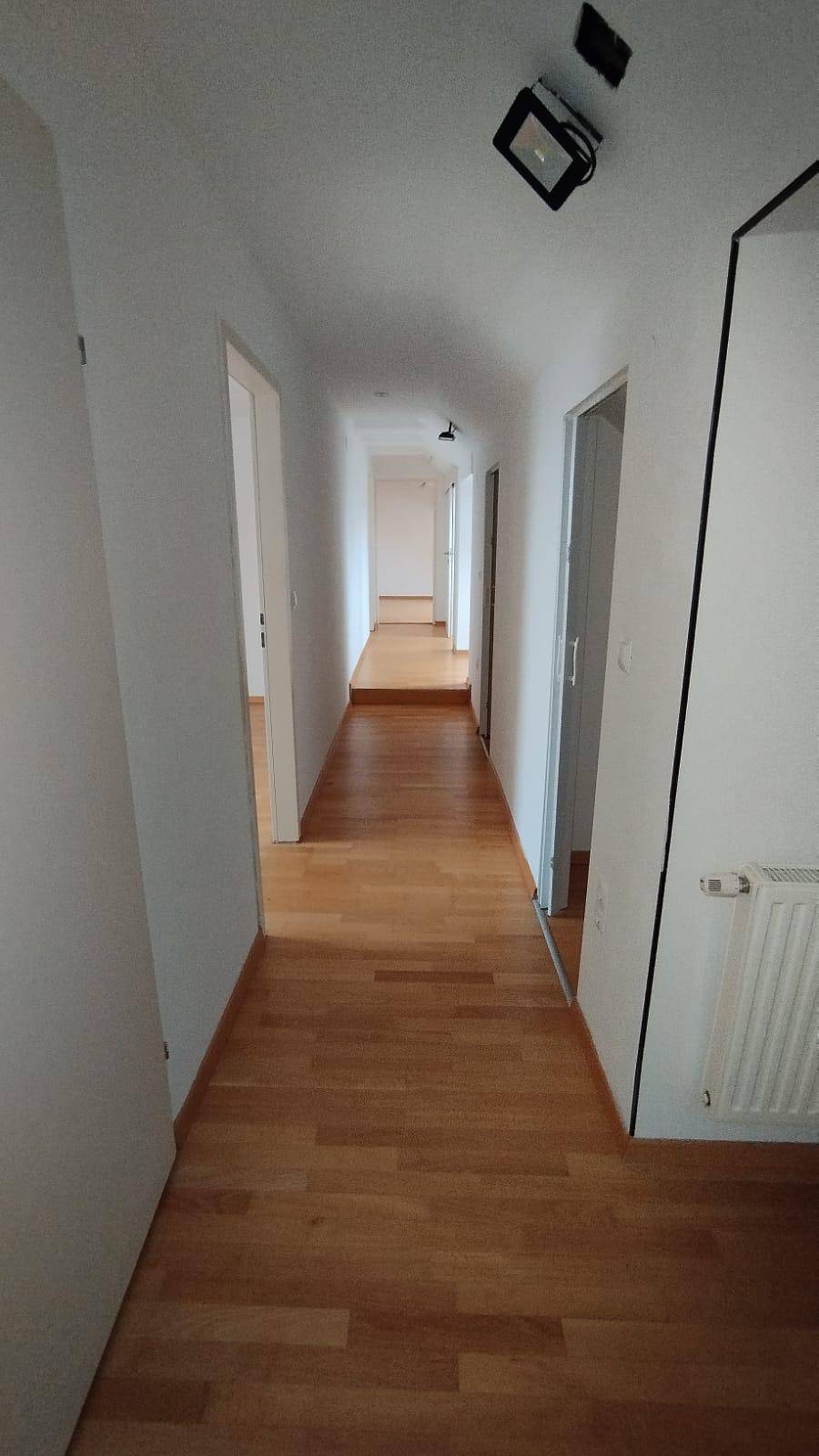 Heller Flur mit Holzparkettboden, der zu weiteren Räumen im Haus führt.
