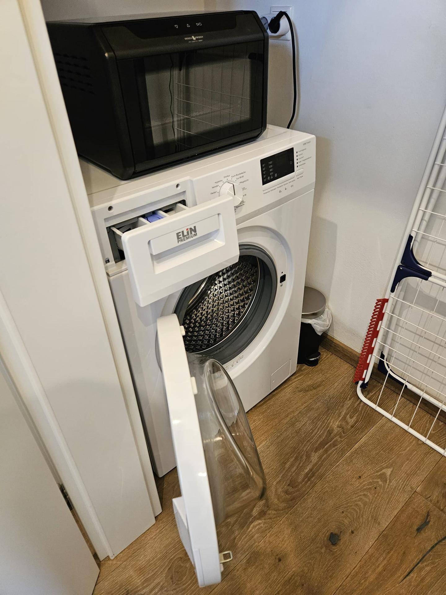 Waschmaschine und kleiner Backofen in einem praktischen Hauswirtschaftsbereich.