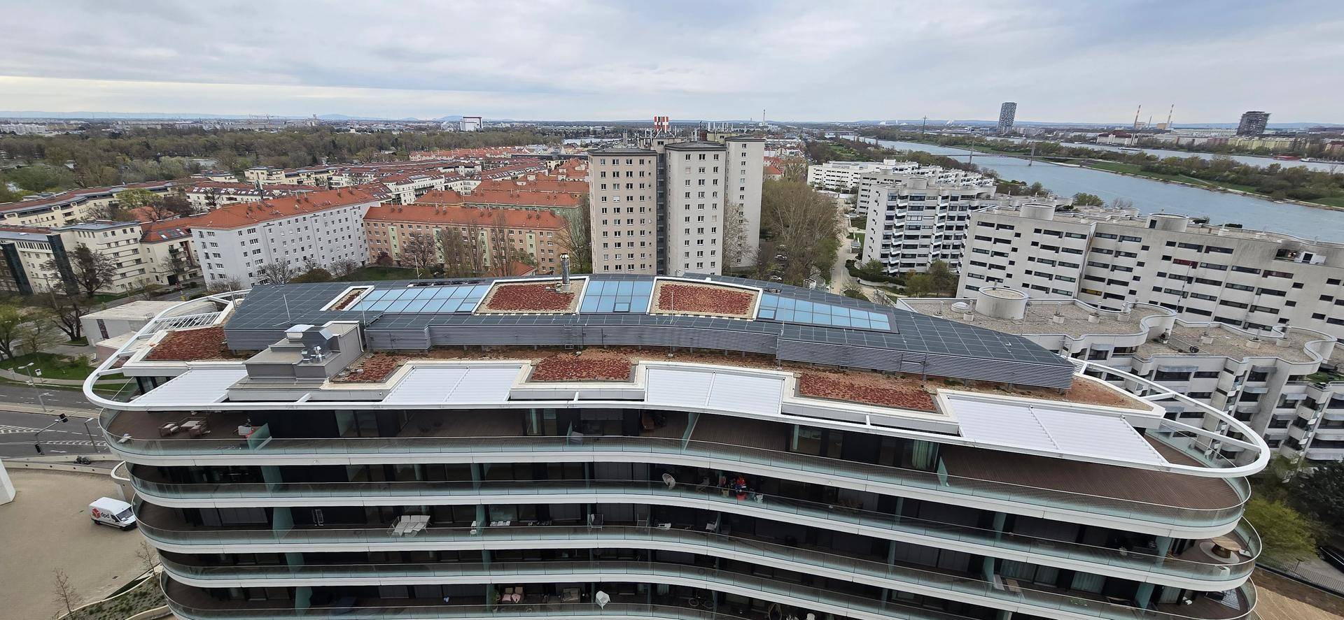 Moderne Architektur des Gebäudes mit geschwungenen Balkonen und weitem Stadtblick.
