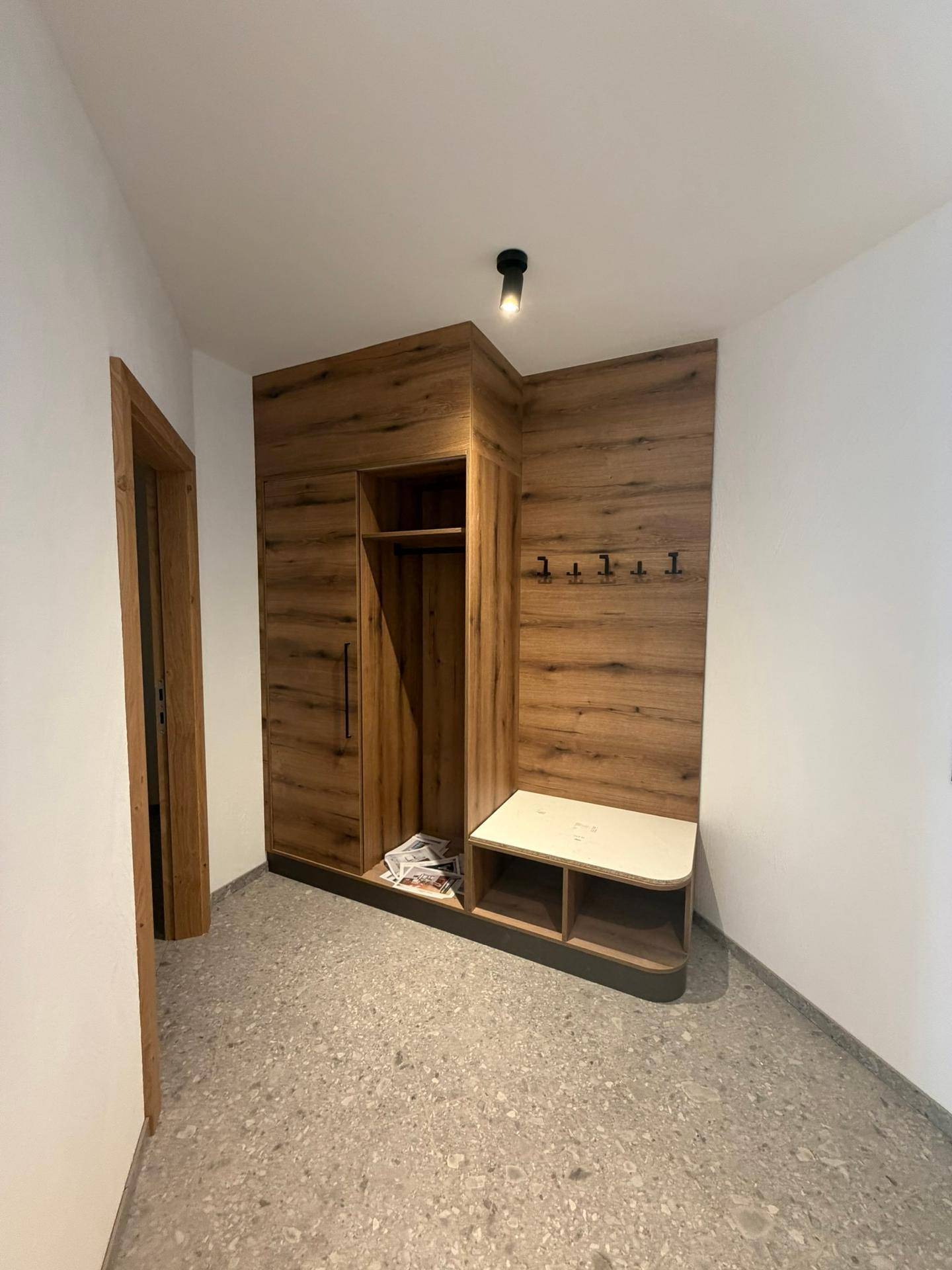 Eingangsbereich mit integrierter Garderobe, Sitzbank und Ablageflächen, ideal für den Empfang.