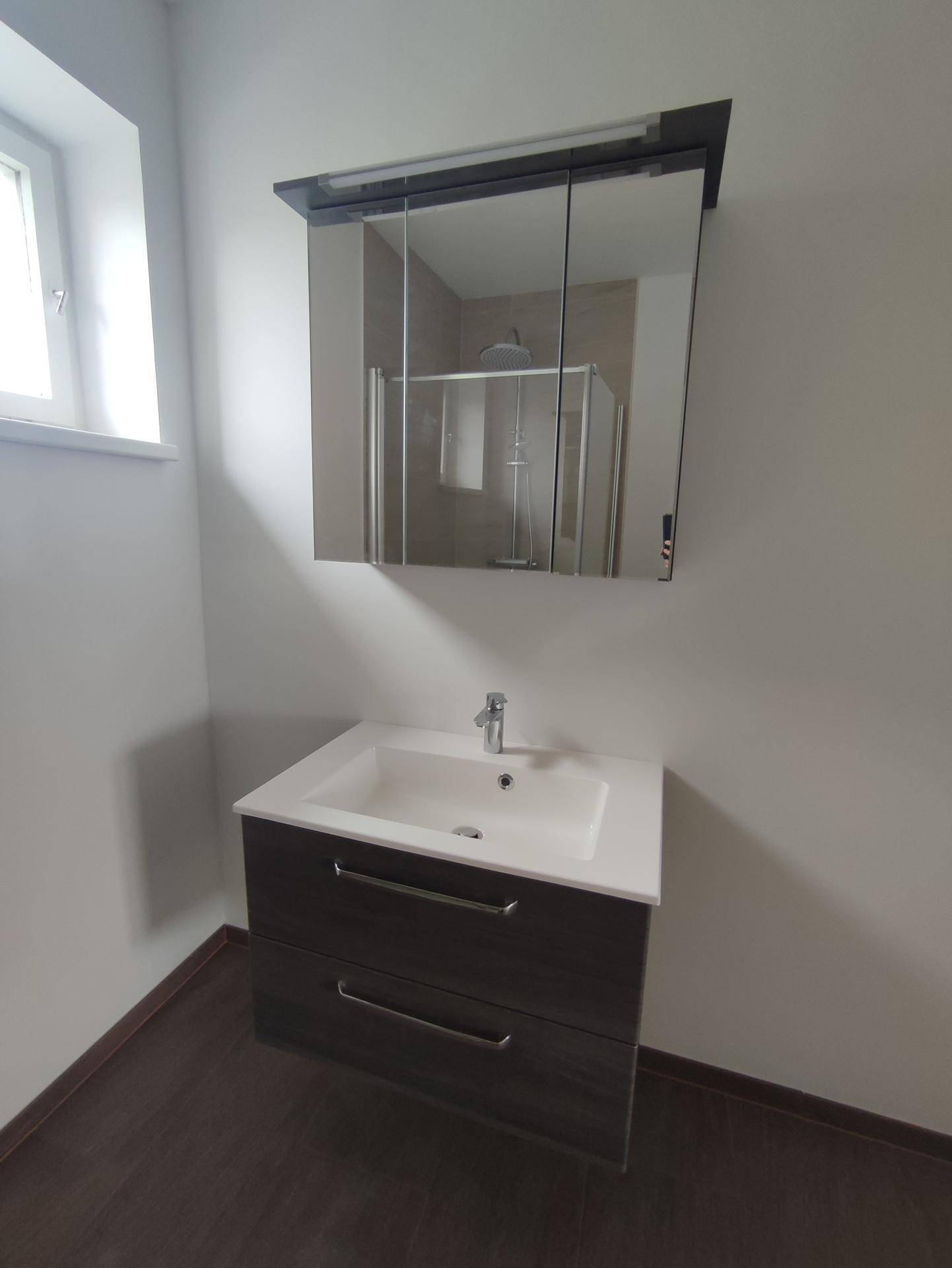 Detailansicht des modernen Waschtischs mit Unterschrank und Spiegelschrank im Badezimmer.