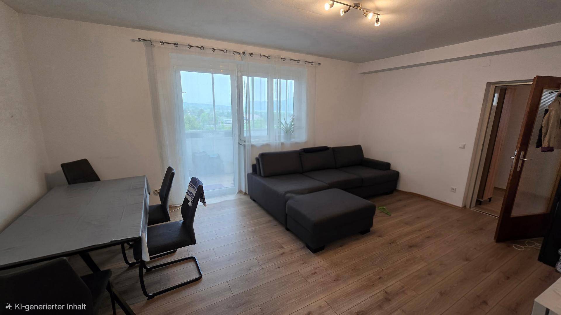 Offener Wohn- und Essbereich mit Holzboden, einem Sofa und Zugang zu einem Balkon, hell und geräumig.
