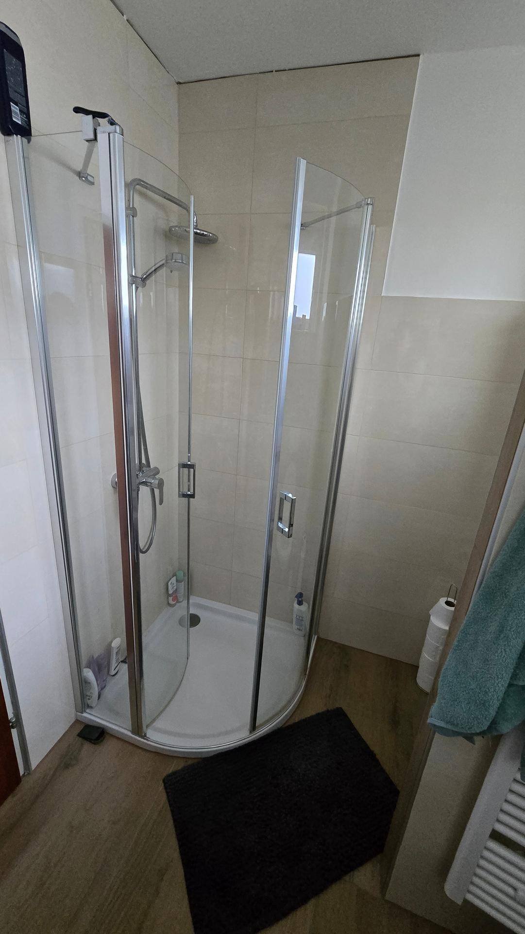 Moderne Duschkabine mit Glaswänden im Badezimmer, funktional und platzsparend in hellem Ambiente.