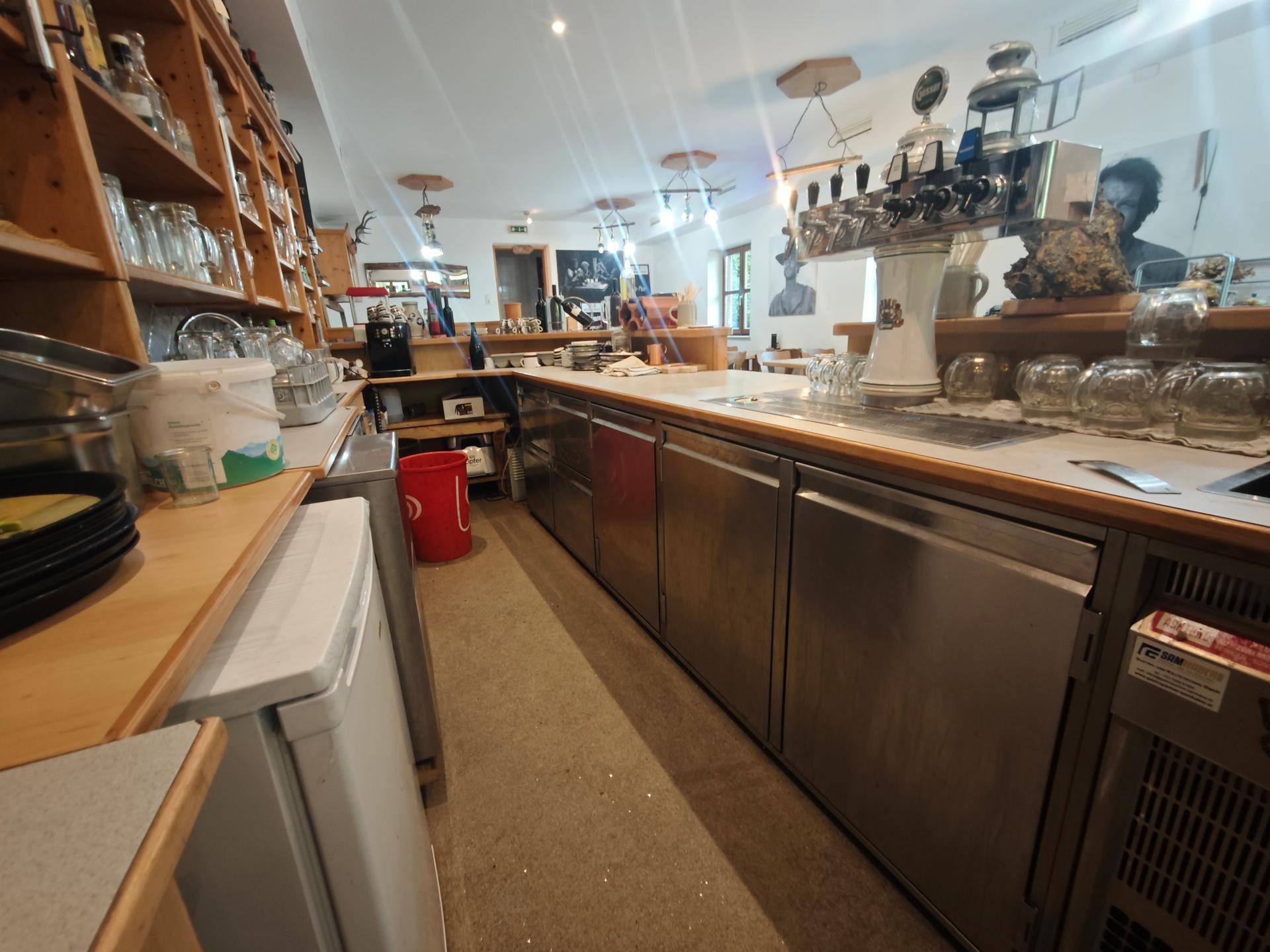 Detailansicht der langen Bar mit Edelstahlfronten, Zapfanlage und Kühlgeräten für den Gastronomiebetrieb.