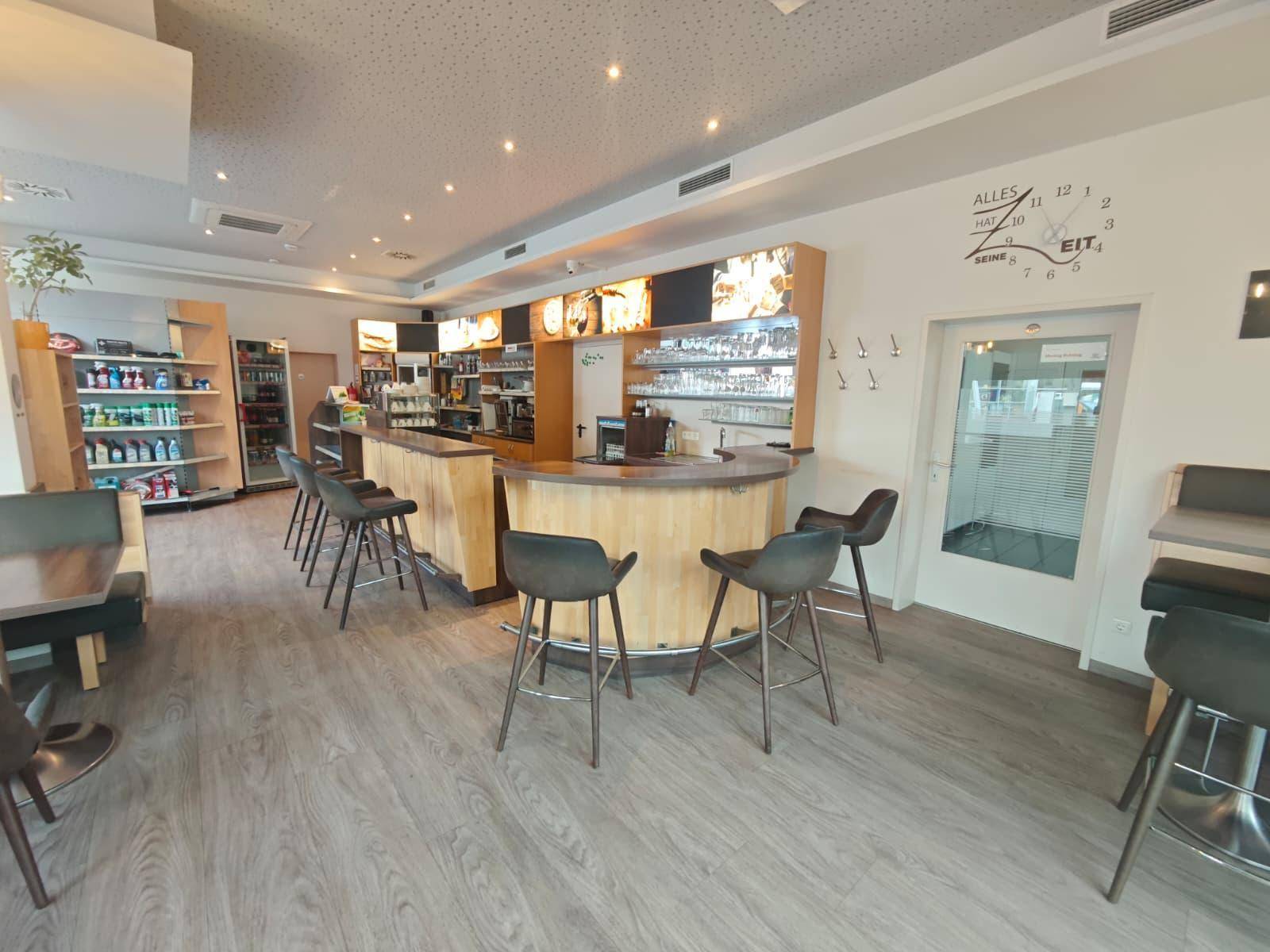 Gemütlicher Bistrobereich mit Holztheke, Barhockern und weiteren Sitzgelegenheiten für Gäste.
