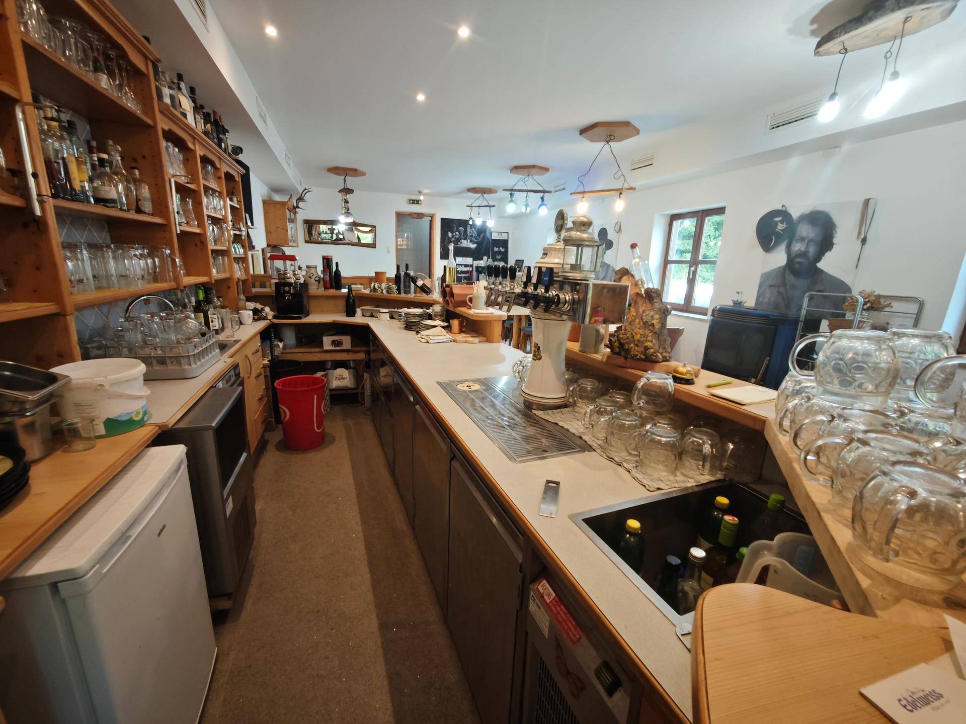 Lange Bar mit Zapfanlage, vielen Gläsern und Flaschen, ideal für Gastronomiebetriebe.