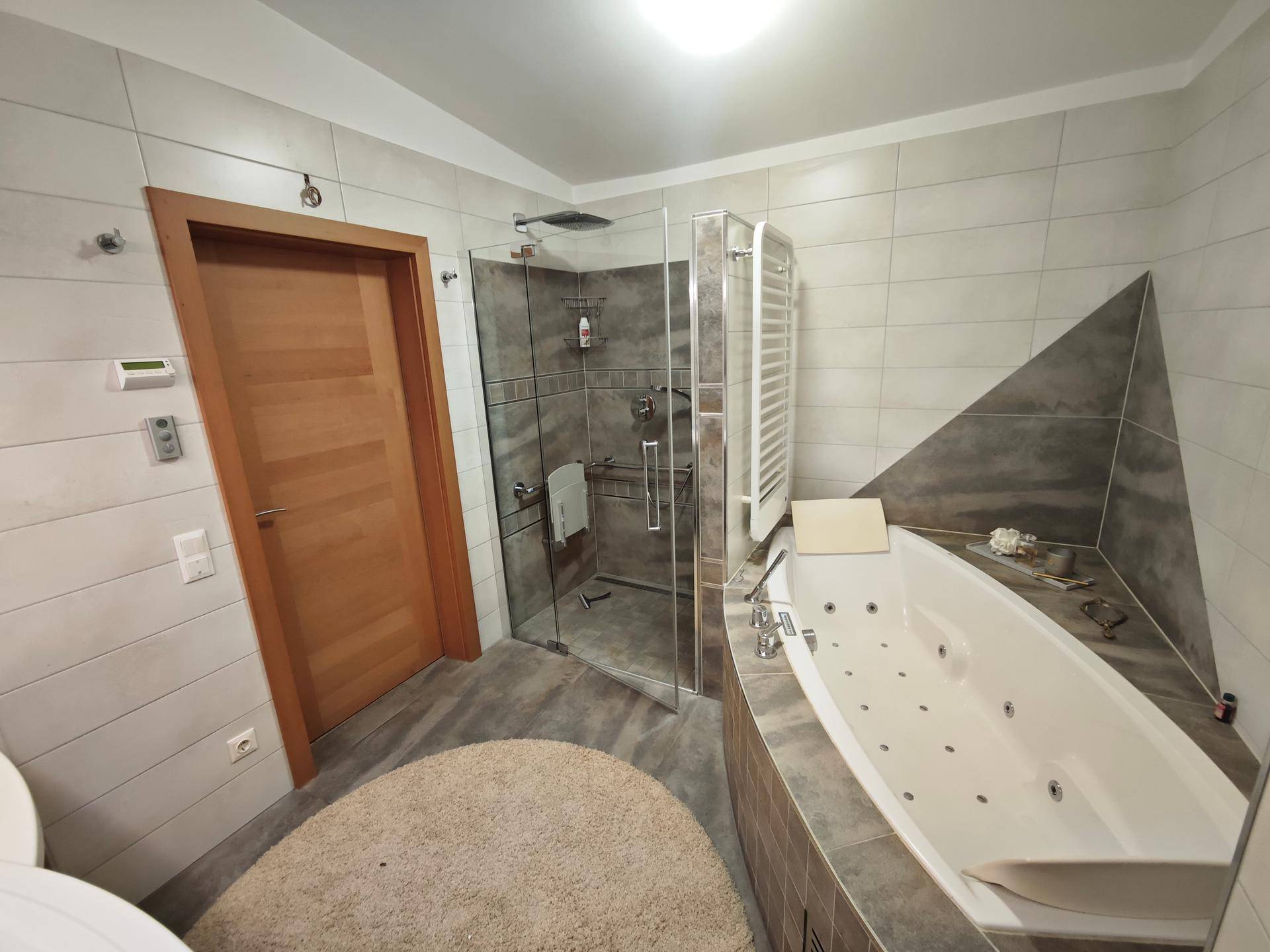 Modernes Badezimmer mit Eckbadewanne, Duschkabine und hellen Fliesen.