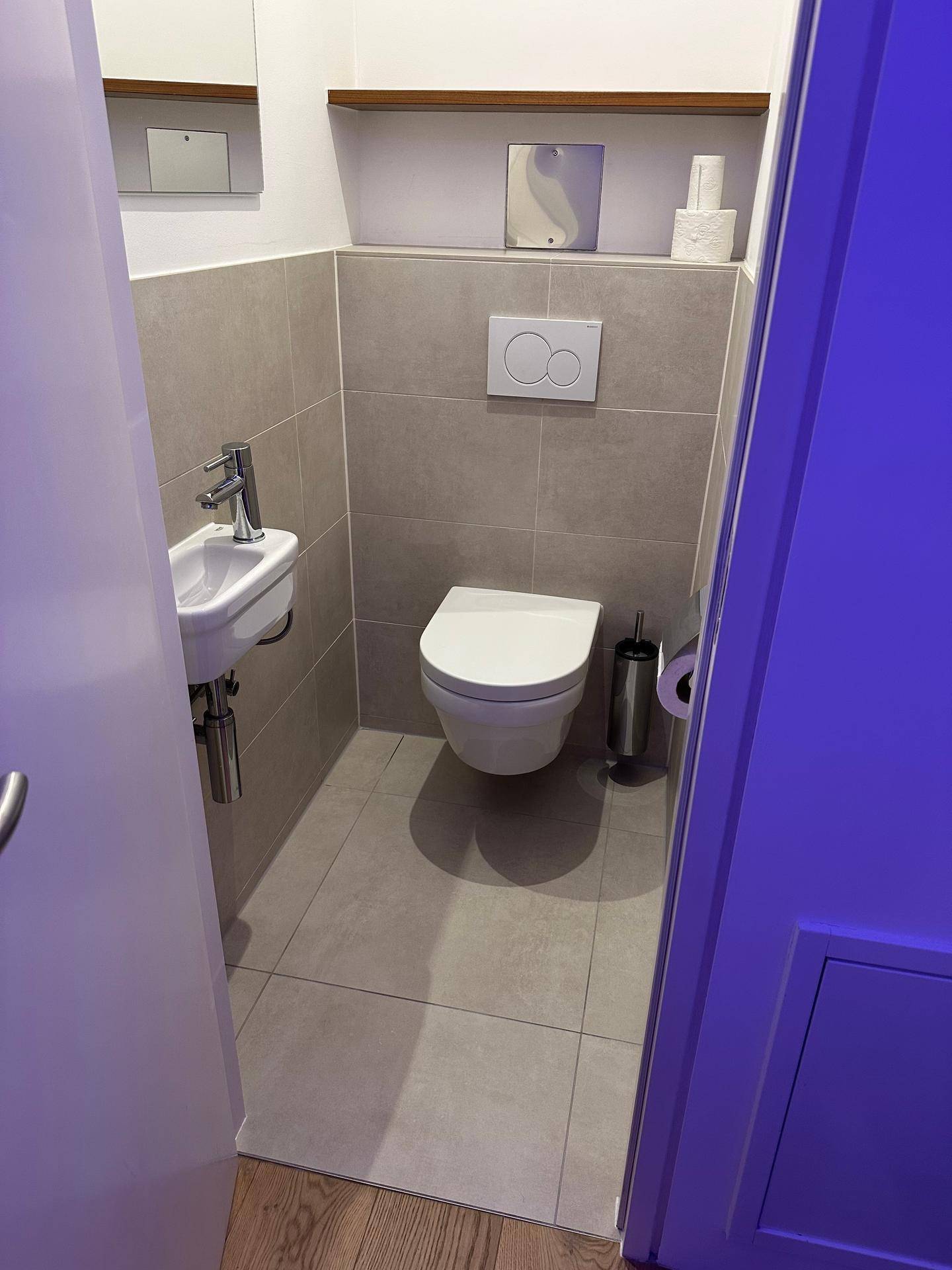 Kleines Gäste-WC mit wandhängender Toilette und kompaktem Waschbecken.