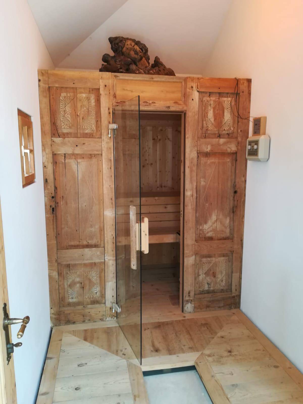 Private Sauna mit rustikalen Holzwänden und Glastür für entspannende Wellness-Momente.