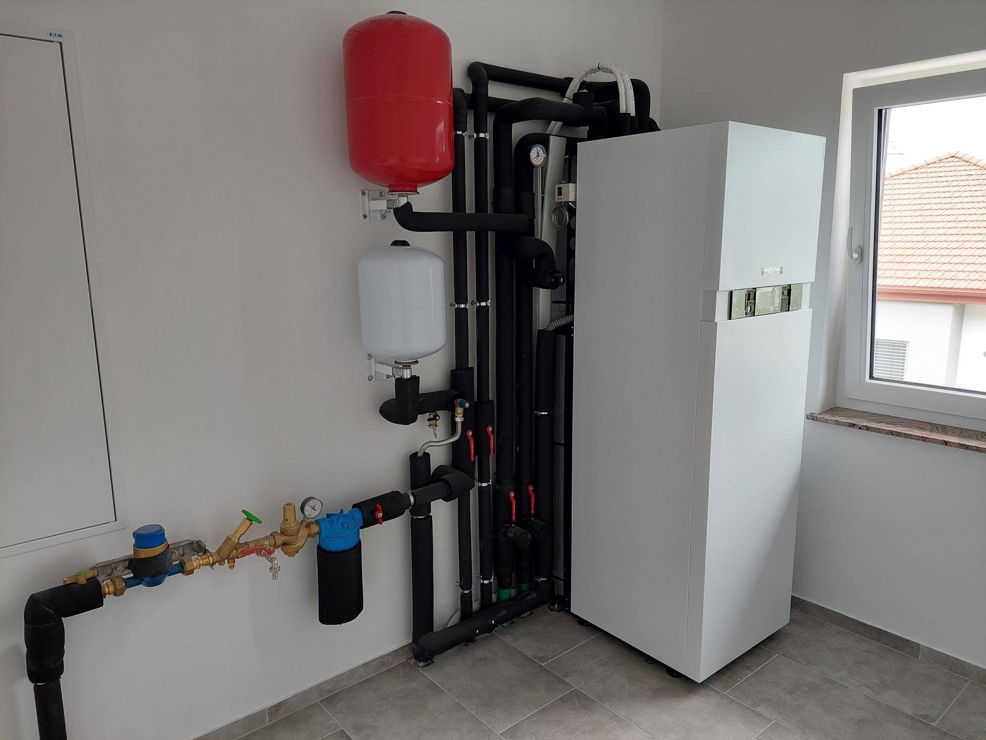 Technikraum mit moderner Heizungsanlage, Warmwasserspeicher und allen notwendigen Installationen.