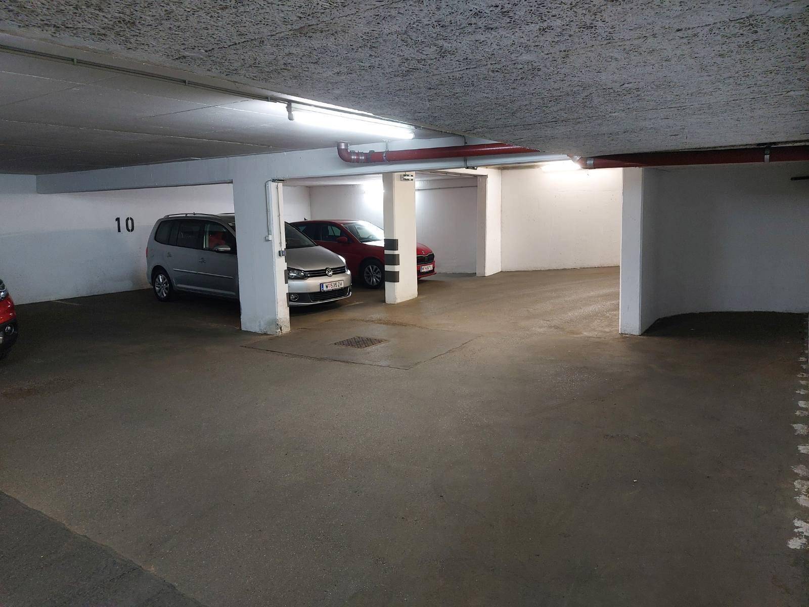 Geräumige Tiefgarage mit mehreren Stellplätzen und Säulenstruktur.