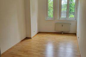 Ruhiges Zimmer mit Parkettboden und Blick ins Grüne, ideal als Schlaf- oder Arbeitszimmer.