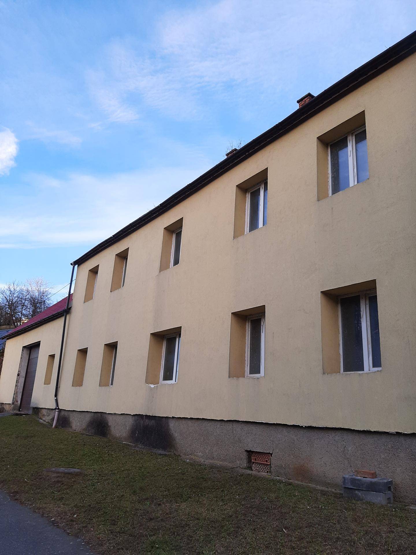 Seitenansicht des gelben Gebäudes mit vielen Fenstern unter blauem Himmel.