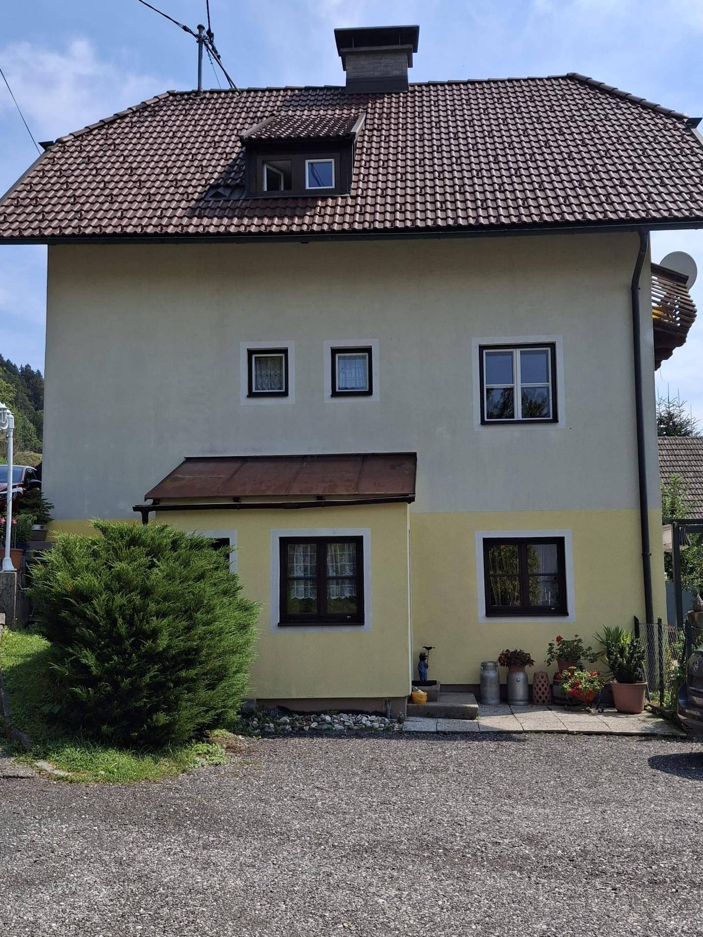 Vorderansicht des Hauses mit kleiner Veranda und gepflegtem Vorgartenbereich.