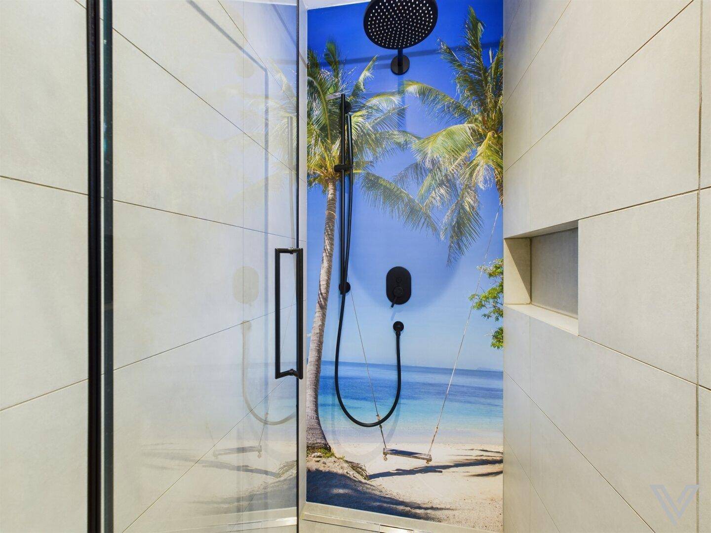 Moderne Dusche mit Glaswand und tropischem Strandmotiv als Wandgestaltung.