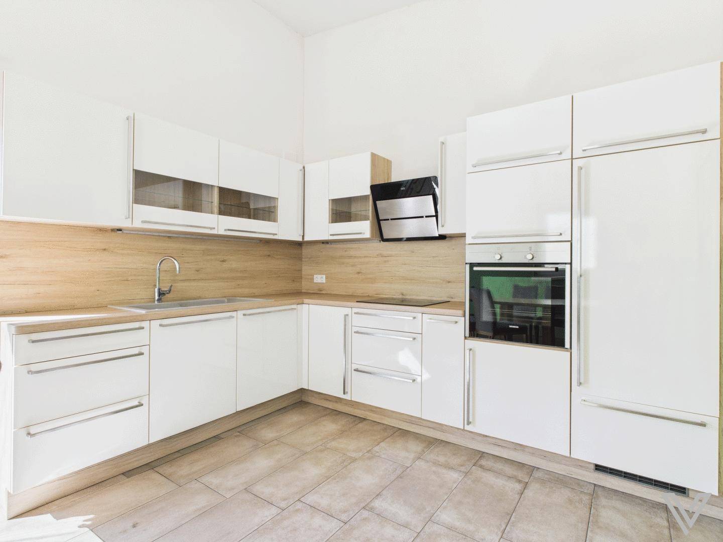 Moderne Einbauküche mit weißen Hochglanzfronten, Holzdetails und integrierten Geräten.