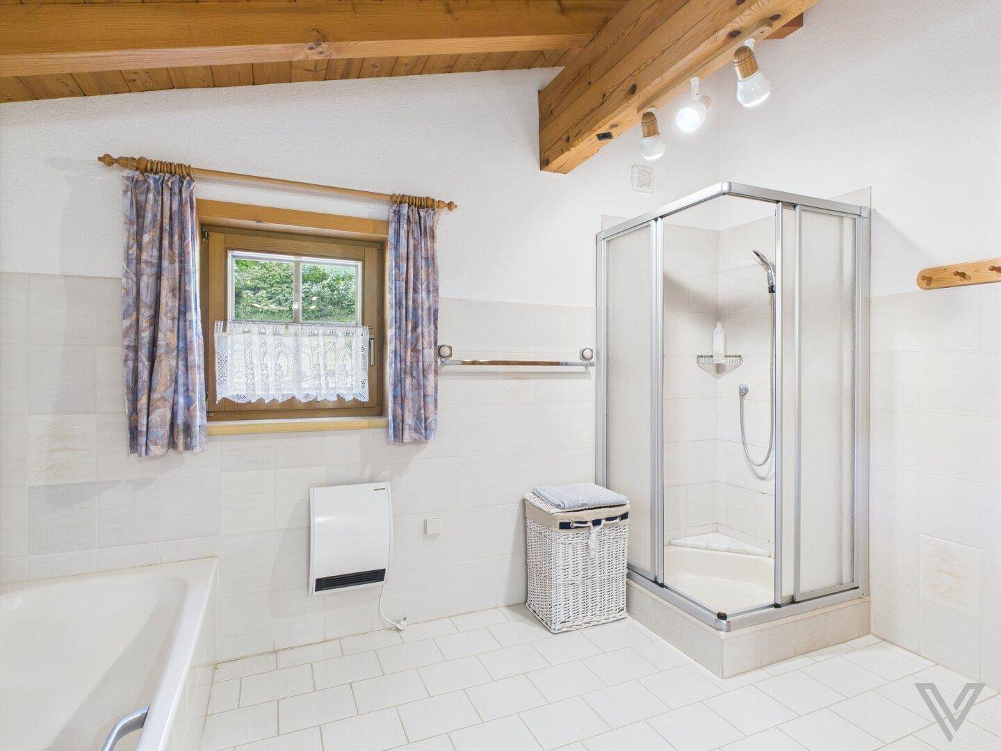 Badezimmer mit Duschkabine, Badewanne und gefliesten Wänden.