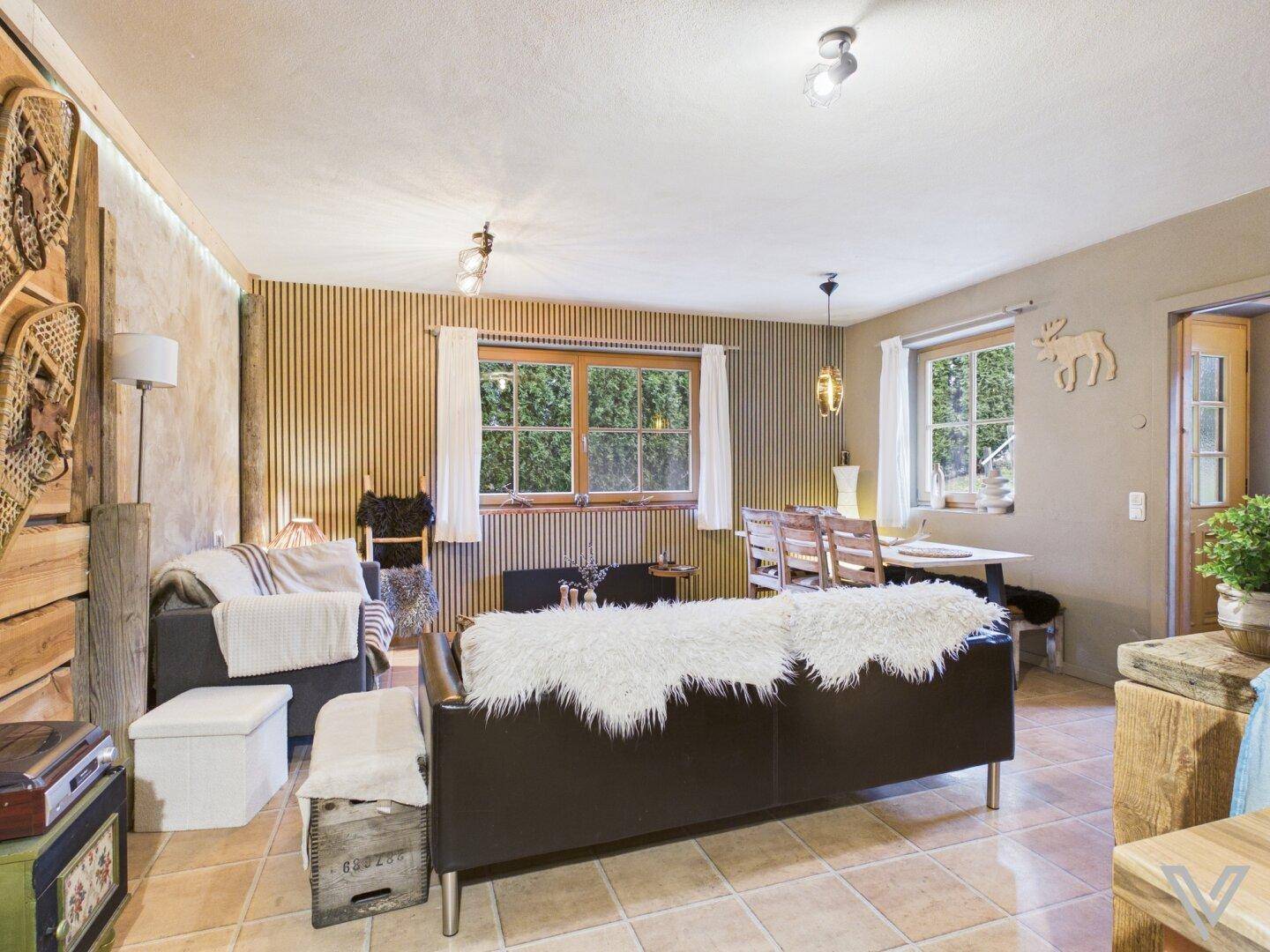 Offener Wohn- und Essbereich mit rustikalen Möbeln und Fliesenboden im Landhausstil.
