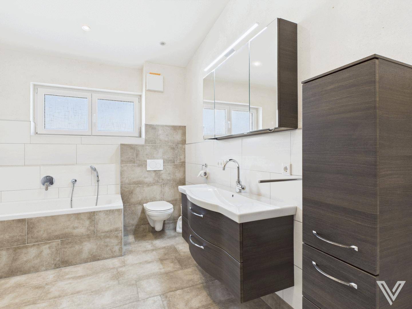 Modernes Badezimmer mit Badewanne, Waschtischunterschrank und Spiegelschrank.