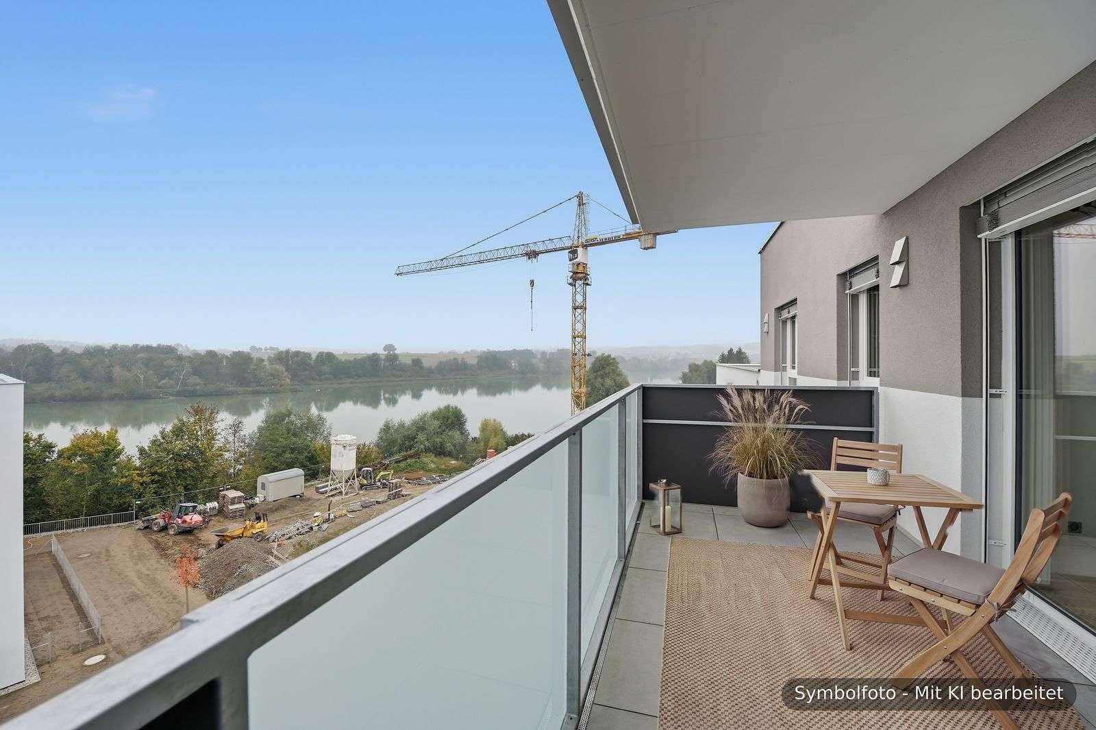 Möblierter Balkon mit Fliesenboden, Sitzgelegenheiten und weitem Blick auf den Fluss.