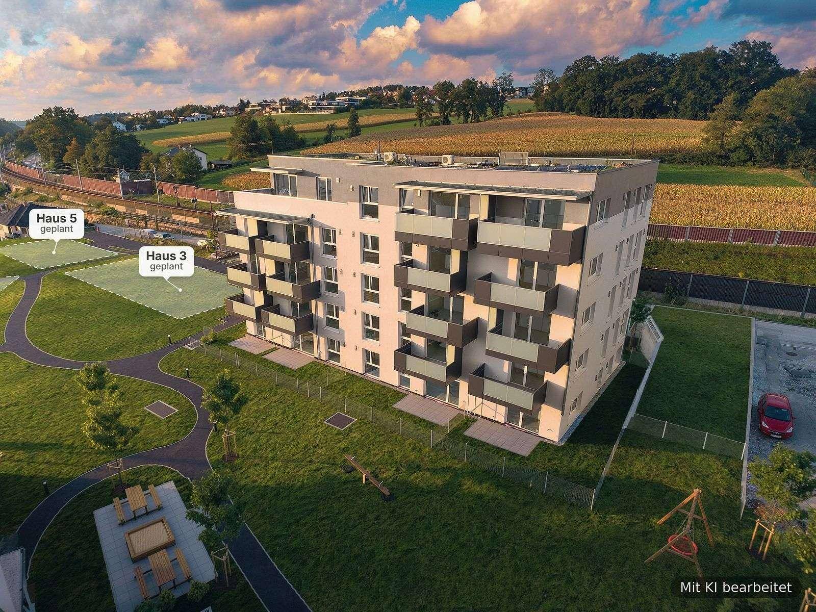 Luftaufnahme eines modernen Wohngebäudes mit geplanten weiteren Häusern in ländlicher Umgebung.