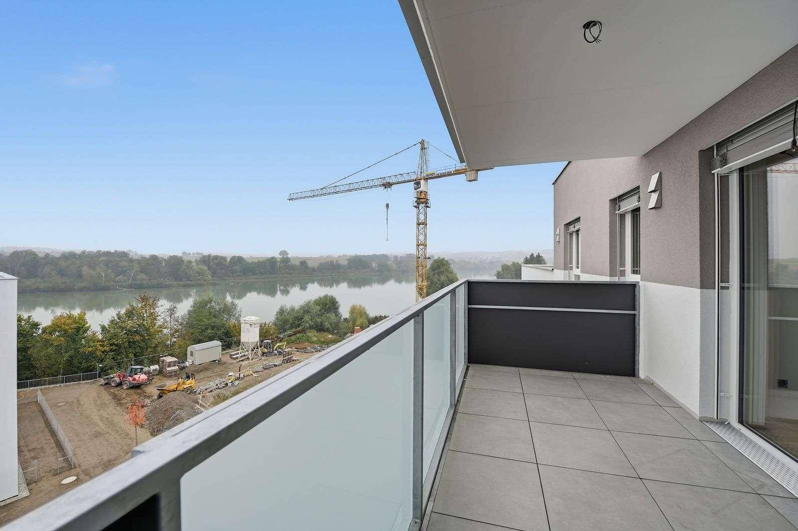 Geräumiger Balkon mit Fliesenboden und weitem Blick auf den Fluss und die Umgebung.