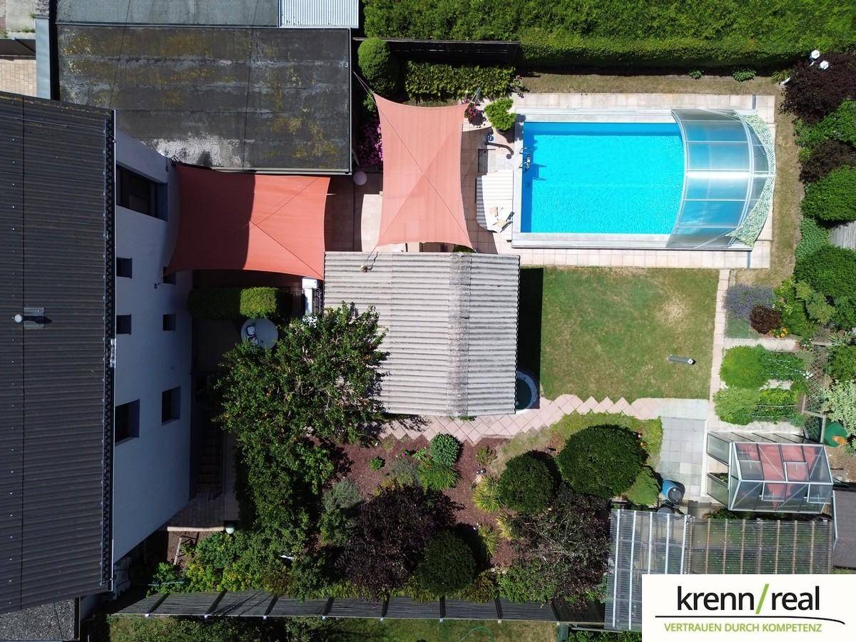 Luftaufnahme des Anwesens mit Garten, Poolbereich und angrenzenden Gebäuden.