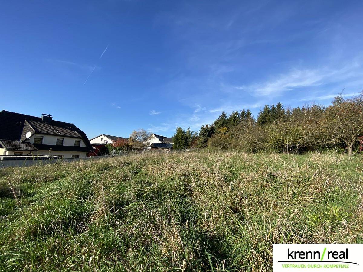 Offenes, sonniges Grundstück mit Blick auf die umliegende Wohnbebauung und Natur.