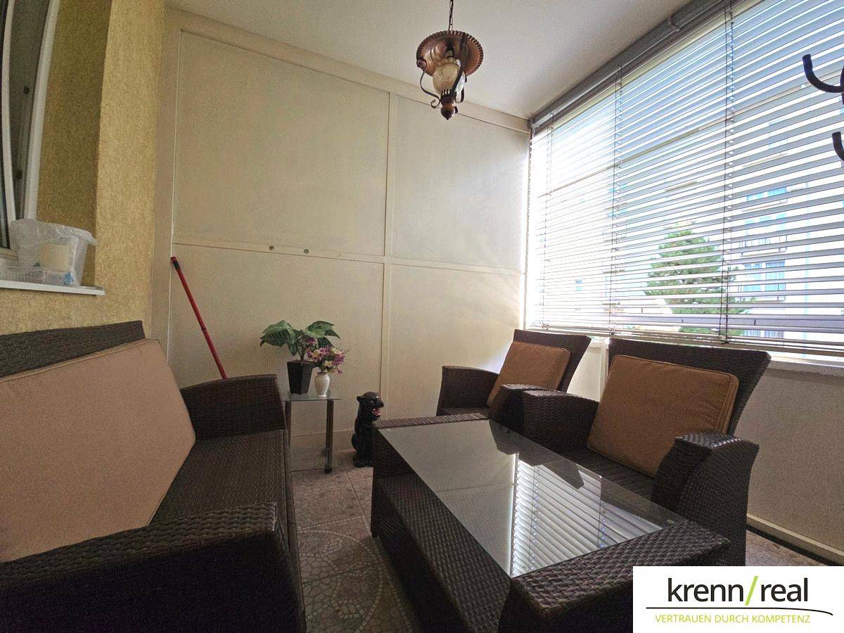 Überdachter Balkon mit Sitzgelegenheiten und Jalousien, ideal für entspannte Stunden im Freien.