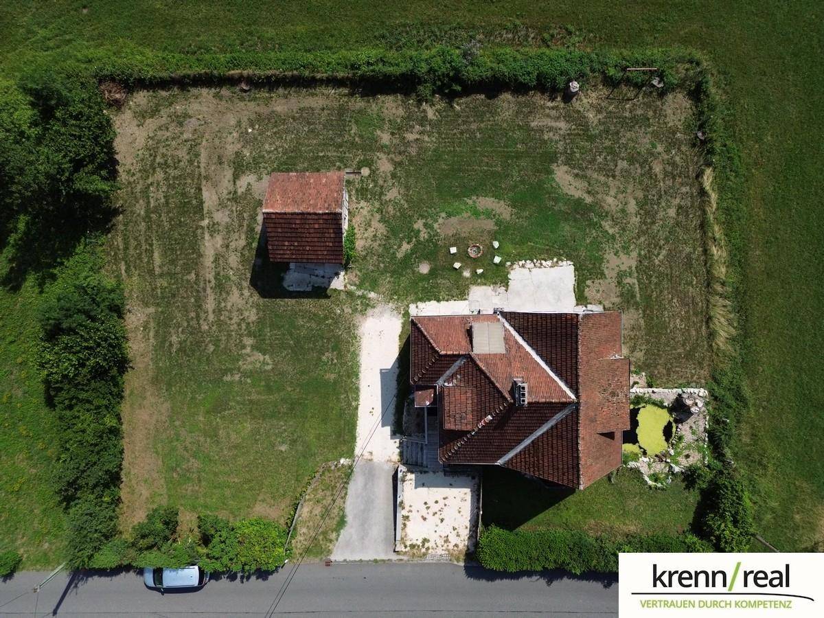 Luftaufnahme des Grundstücks mit Wohnhaus, Nebengebäude und großem Gartenbereich.