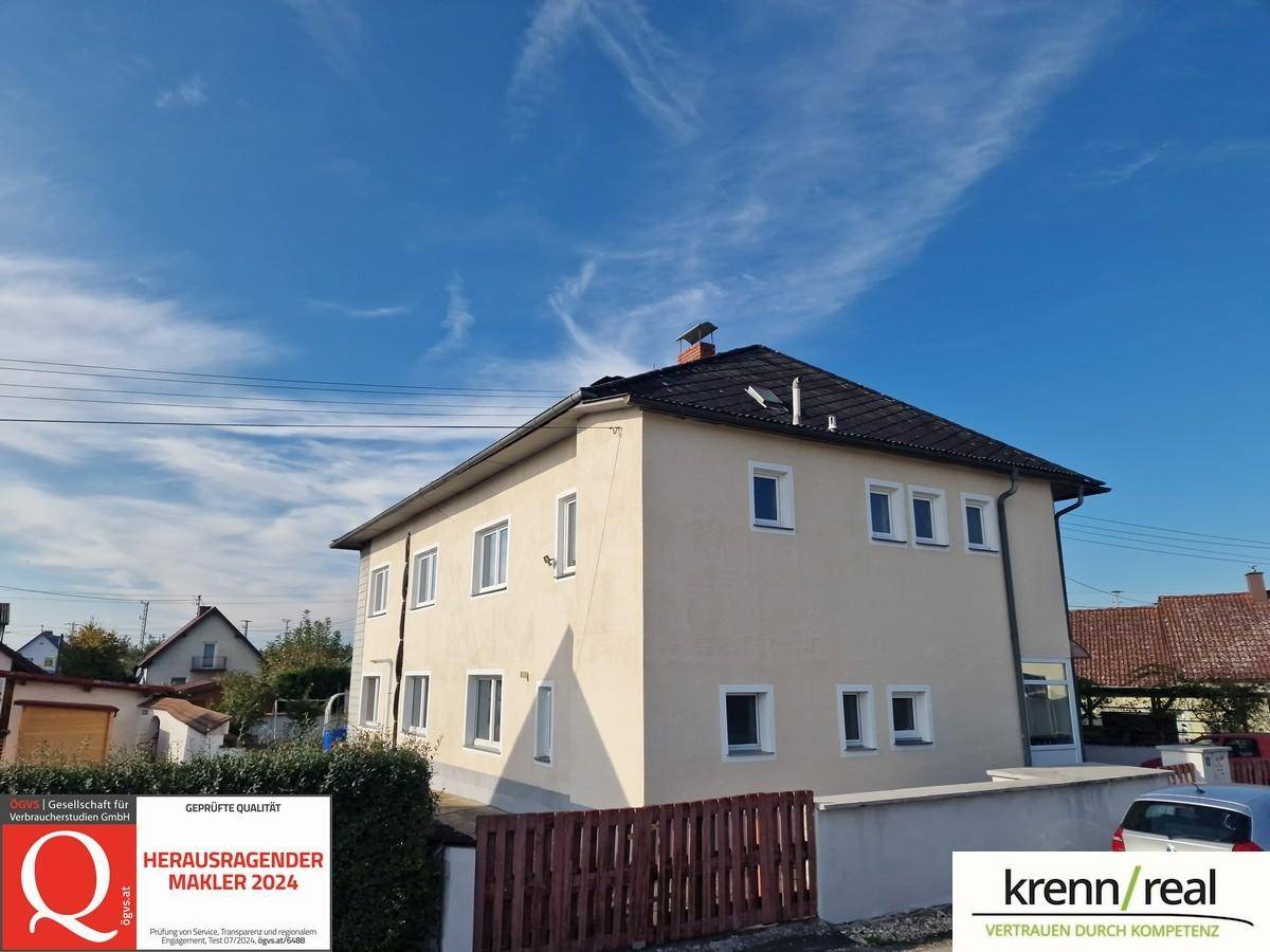 Ansicht des gepflegten Hauses von der Straße aus mit hellem Putz und Satteldach.