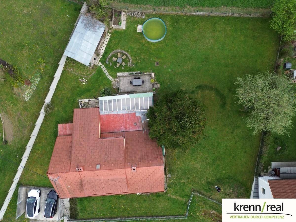 Luftaufnahme des Anwesens mit rotem Dach, großem Garten, Pool und Außenbereich.