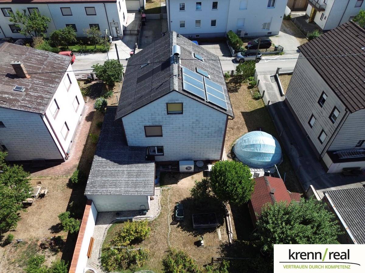 Draufsicht auf das Haus mit Solaranlage auf dem Dach und dem umliegenden Gartenbereich.