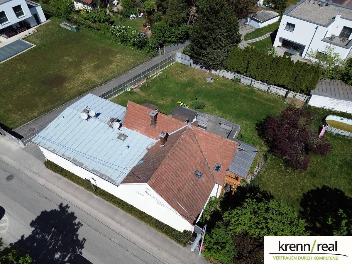 Vogelperspektive des Anwesens mit Dachflächen, Garten und umliegenden Häusern und Straßen.