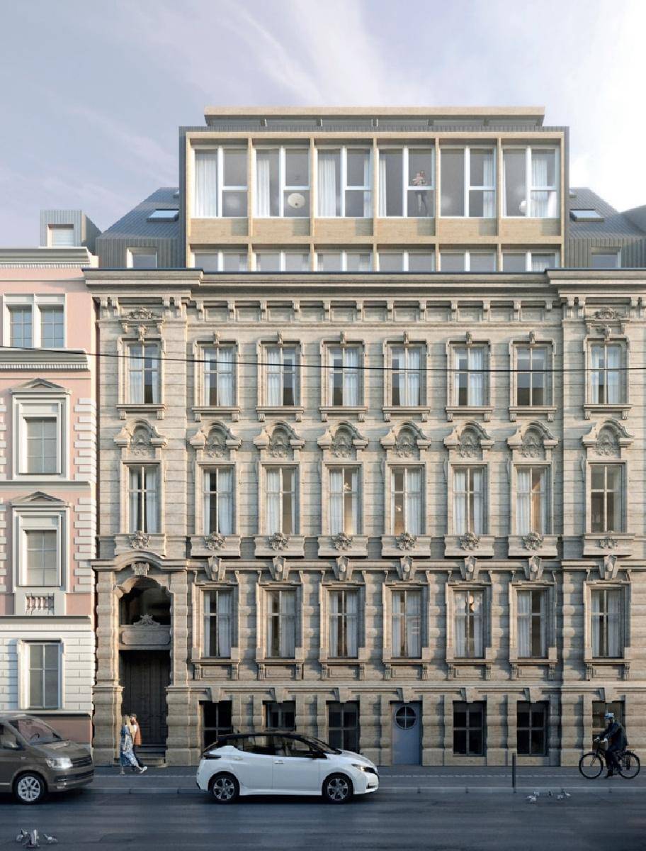Historische Fassade mit eleganter Architektur und moderner Dachgeschossaufstockung in urbaner Umgebung.