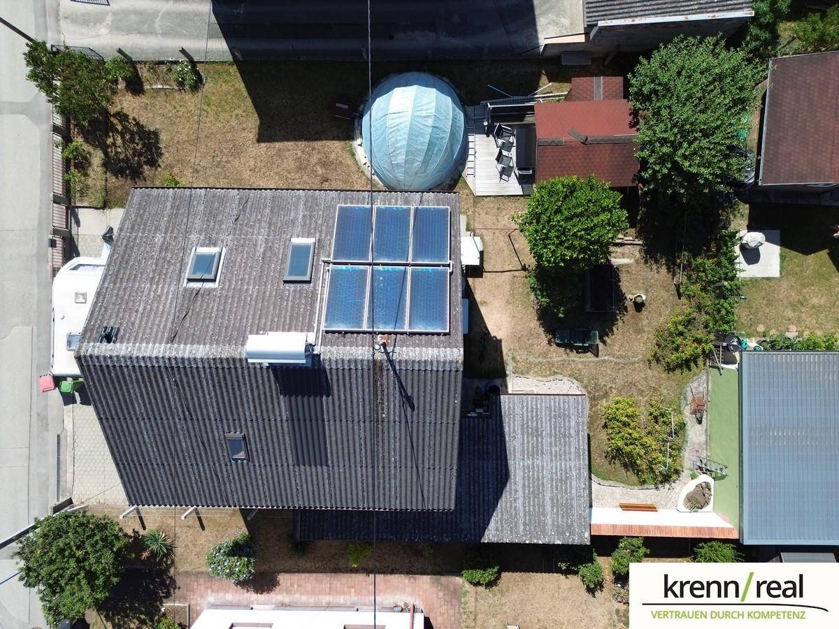 Nahaufnahme des Daches mit installierter Solaranlage und Dachfenstern.