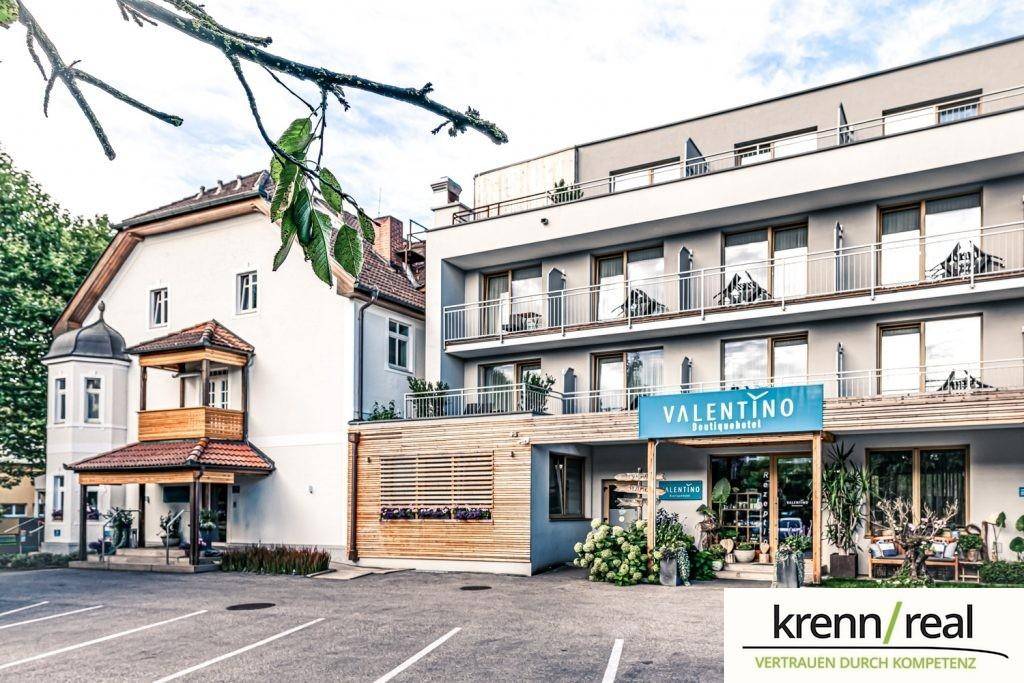 Tagesansicht des Hotels mit Eingangsbereich, Parkplätzen und moderner Fassade.